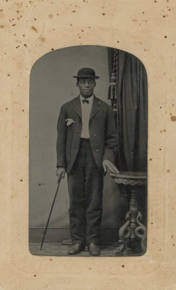 Item #List1808 Portrait of a Young African-American Man With a Hat and Cane, 1860s - 1870s. African-Americana - Vernacular Photography - Tintypes.